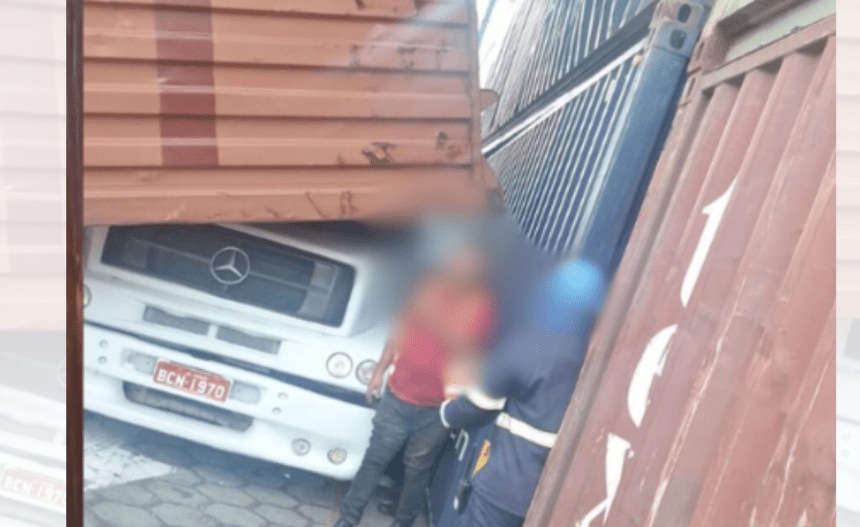 Imagem colorida mostra contêineres caídos em caminhão e motorista saindo