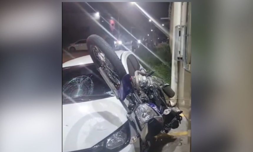 Acidente de trânsito: motocicleta colide com carro, vidro quebrado e moto em cima.