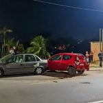 Acidente de trânsito na Avenida do Turismo envolvendo dois carros, com pessoas no local e luzes noturnas.