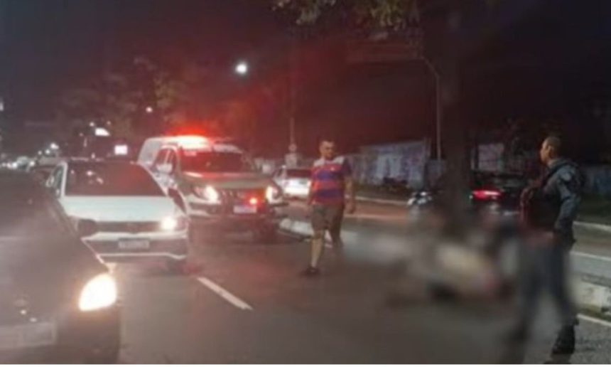 Acidente de trânsito noturno: homem atropelado na rua com ambulância no local.