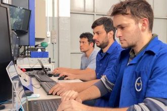 Alunos do ITA trabalhando em computadores em laboratório.