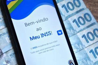 Aplicativo Meu INSS em um smartphone com notas de dinheiro ao fundo