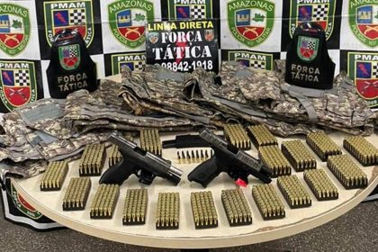 Apreensão de armas, munições e coletes da Polícia Militar em mesa.