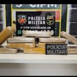 Apreensão de drogas pela Polícia Militar: pacotes de substância ilícita sobre uma mesa.
