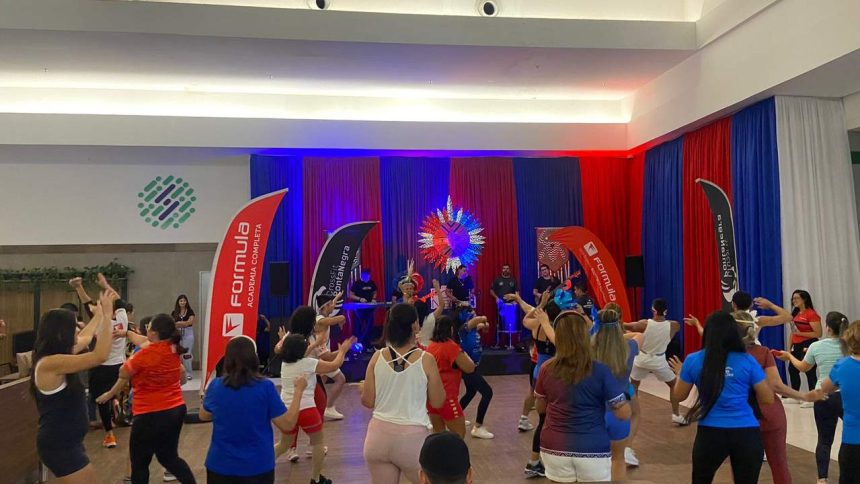 Aulão de Boi Bumbá no Shopping Ponta Negra, com pessoas dançando e banda no palco.