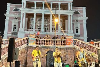 Banda se apresenta em evento da Virada Sustentável em Manaus, com o Teatro Amazonas ao fundo.