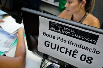 Bolsa Pós-Graduação: funcionária atende em guichê
