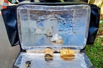 Bolsa térmica de entrega com dinheiro e drogas apreendidas.