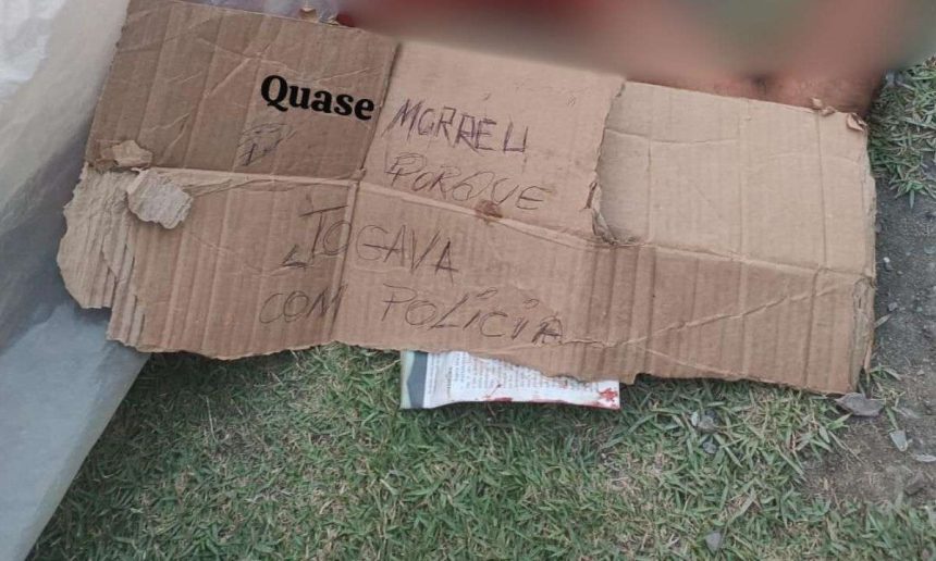 Cartaz de papelão com escrita sobre crime em Manaus: 'Quase morri porque jogava com a polícia'.