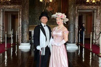 Casal em trajes de época posando em frente ao Teatro Amazonas.