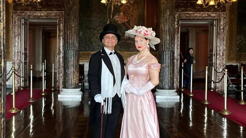 Casal em trajes de época posando em frente ao Teatro Amazonas.