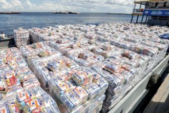 Cestas básicas embaladas em barco para entrega a famílias afetadas pelas enchentes no Amazonas.