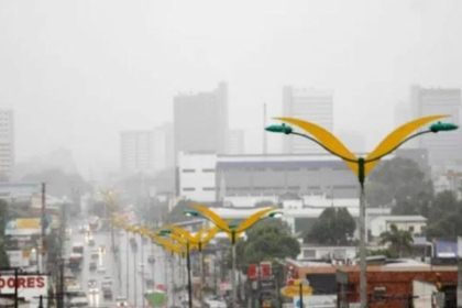 Chuvas em Manaus: vista de avenida com postes de luz e edifícios ao fundo.