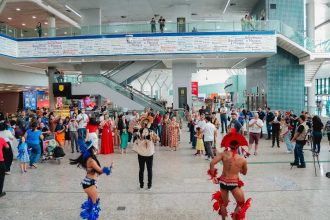Dançarinos e público no aeroporto de Manaus em evento especial.