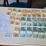 Dinheiro e documentos apreendidos em caso de falsa identidade.