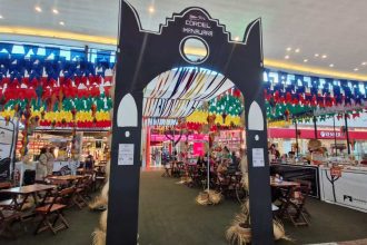 Entrada para o evento Cordel Manauara em shopping com decoração junina e pessoas