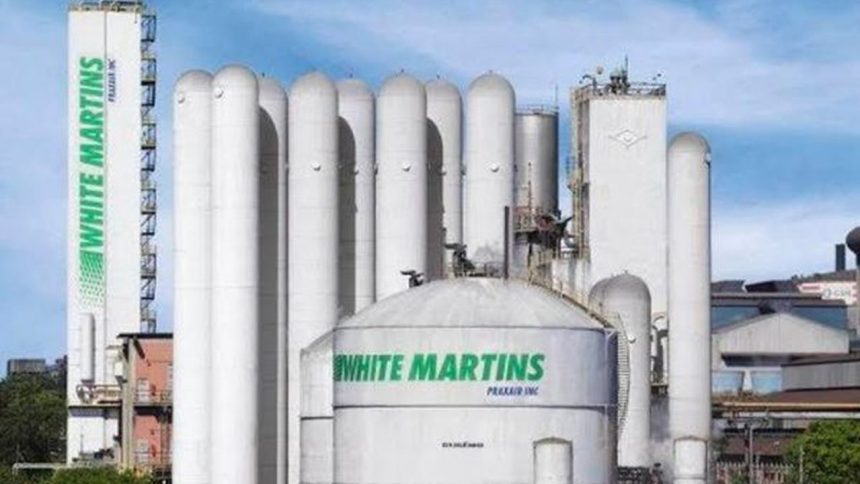 Fábrica da White Martins com tanques e torres brancas, representando indústria de gases.