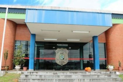 Fachada da delegacia de homicídios com a inscrição 'Homicídios' e brasão da Polícia Civil.