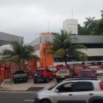Fachada da empresa Bringel em Manaus, com carros estacionados e palmeiras.
