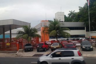 Fachada da empresa Bringel em Manaus, com carros estacionados e palmeiras.