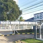Fachada da fábrica da Jabil em Manaus, com o letreiro 'JABIL' em destaque e uma entrada com portão.