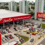 Fachada da loja Nova Era em Manaus, com estacionamento lotado e letreiro