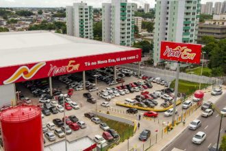 Fachada da loja Nova Era em Manaus, com estacionamento lotado e letreiro