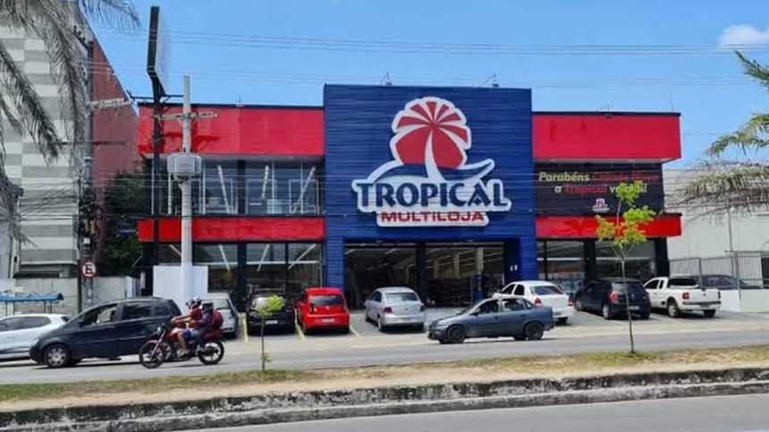 Fachada da loja Tropical Multiloja em Manaus, com carros estacionados.