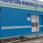 Fachada da Prefeitura Municipal de Itamarati, em tom azul, com placa e mastros.