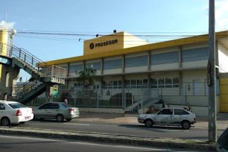 Fachada da Prosegur em Manaus, com carros na rua e passarela.