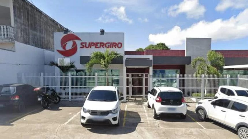 Fachada da Supergiro, distribuidora em Manaus, com carros estacionados e letreiro.