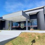 Fachada de delegacia de polícia civil em dia ensolarado.