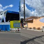 Fachada de estádio com banners e banheiros químicos, e rua com mesas e guarda-sol, em Parintins.