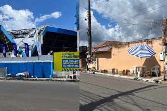 Fachada de estádio com banners e banheiros químicos, e rua com mesas e guarda-sol, em Parintins.