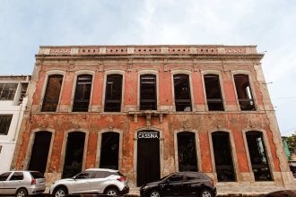 Fachada do Casarão de Inovação Cassina, prédio histórico em tons de vermelho e janelas escuras.