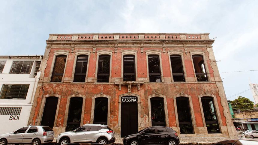 Fachada do Casarão de Inovação Cassina, prédio histórico em tons de vermelho e janelas escuras.