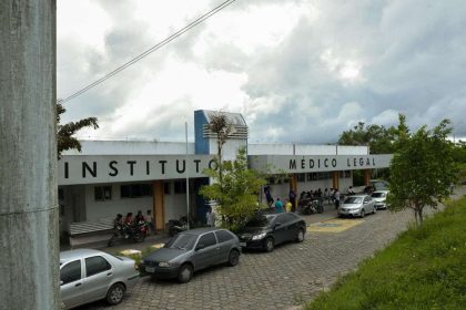 Fachada do Instituto Médico Legal (IML) com carros e pessoas