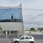 Fachada do Ministério Público do Trabalho, com carro e ciclista na frente.