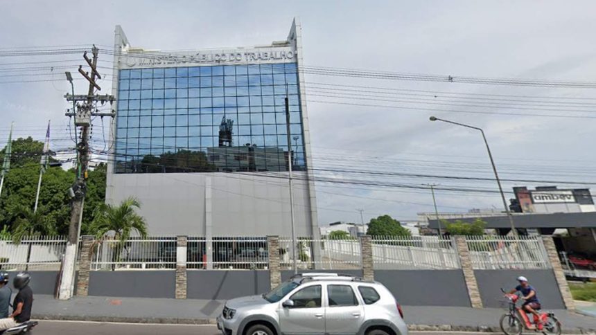 Fachada do Ministério Público do Trabalho, com carro e ciclista na frente.
