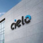 Fachada do prédio da Cielo com logo em destaque e céu azul ao fundo.