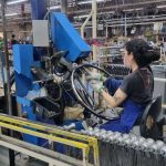 Funcionária da Caloi trabalha em linha de produção em Manaus, montando aros de bicicleta.