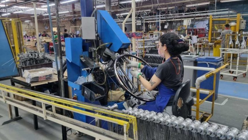 Funcionária da Caloi trabalha em linha de produção em Manaus, montando aros de bicicleta.