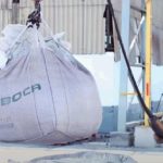 Funcionário da Mineração Taboca em Presidente Figueiredo com equipamento de proteção e saco de material sendo içado.