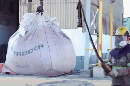 Funcionário da Mineração Taboca em Presidente Figueiredo com equipamento de proteção e saco de material sendo içado.