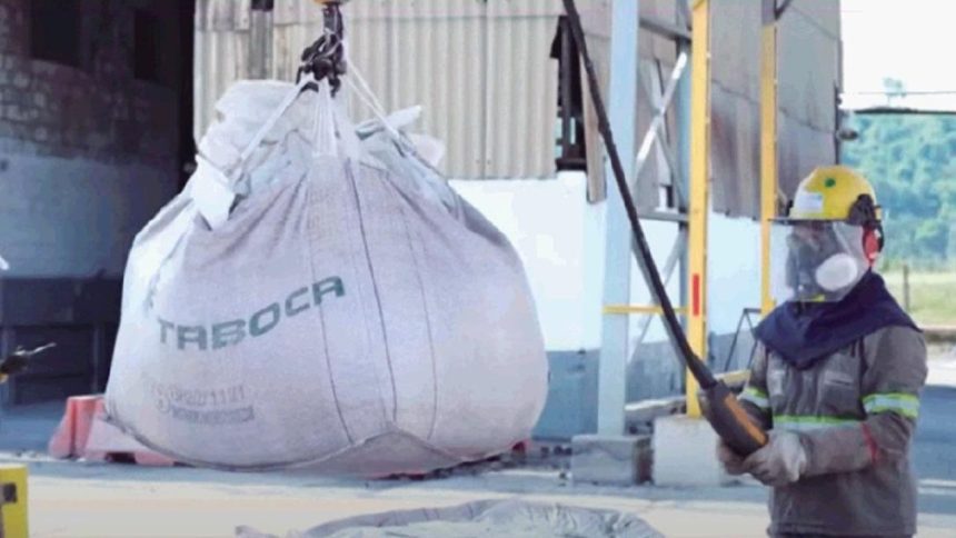 Funcionário da Mineração Taboca em Presidente Figueiredo com equipamento de proteção e saco de material sendo içado.