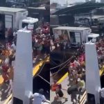 Grande fluxo de pessoas desembarcando de navio no Porto de Manaus, com caminhões ao fundo.