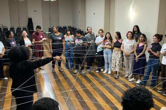 Grupo de pessoas em círculo em um workshop, com fios de barbante conectados.