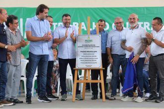 Grupo de pessoas em evento de inauguração, com placa de 'Pavimentação do Sistema Viário de Itacoatiara'.