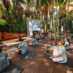 Grupo praticando yoga ao ar livre em evento de shopping