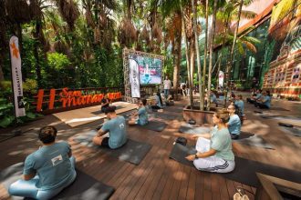 Grupo praticando yoga ao ar livre em evento de shopping